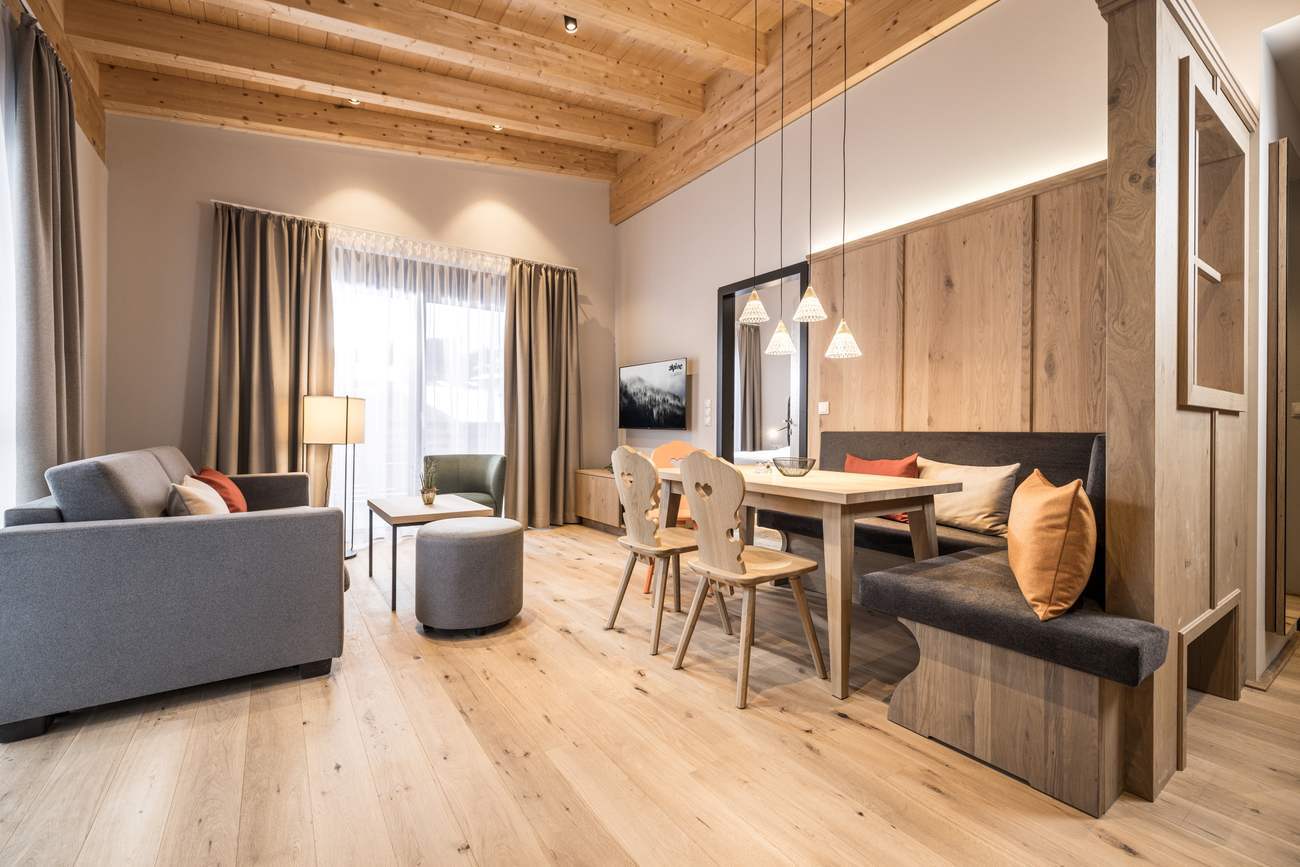 Apartment W10, 1 SZ Superior, 46,20 m² in Niederau — Wohnbereich mit Sofa und Essplatz